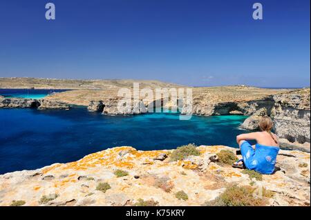 Malta e Comino Isola, Comino, laguna blu e il Cristal Laguna, giovane donna ammirando la vista Foto Stock