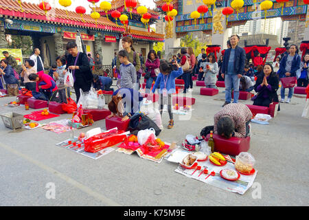 Hong Kong, Cina - 22 gennaio 2017: la folla di persone in possesso di una loro mani un bastoncini di incenso e di pregare all'interno di wong tai sin tempio buddista a pregare, a Hong Kong, Cina Foto Stock