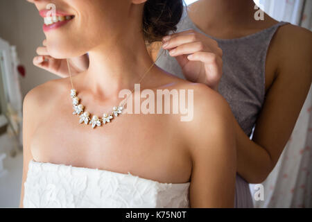 Sezione mediana della damigella bride di fissaggio collana in spogliatoio Foto Stock