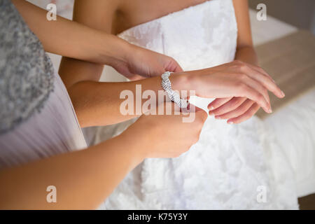 Angolo di elevata sezione mediana della damigella medicazione sposa nella sala di montaggio Foto Stock