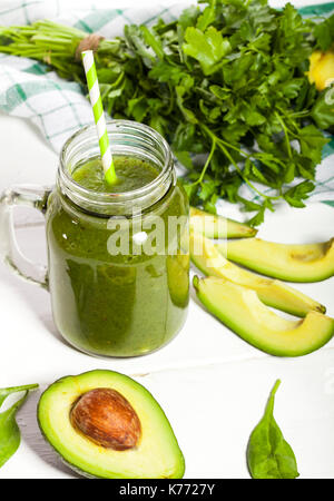 Appena miscelato frullato verde in vetro con paglia bianco su sfondo di legno Foto Stock