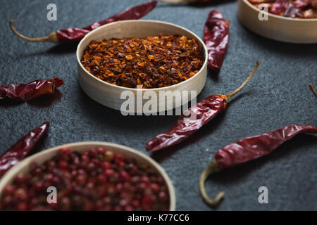 Close-up di essiccato peperoncino rosso e il peperoncino rosso tritato nel recipiente Foto Stock