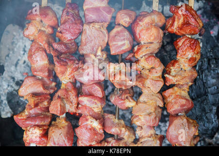 Primo piano di alcuni spiedini di carne alla griglia essendo in un barbecue Foto Stock