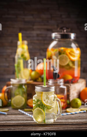 Fresche di agrumi freschi limonata acqua infusa nel vasetto di vetro con paglia Foto Stock