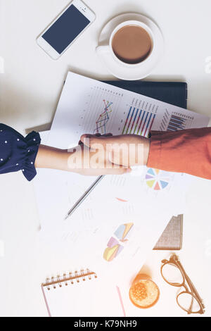 Stringe la mano in occasione di una riunione. Due imprenditore fiducioso di sedere al tavolo delle trattative in ufficio. Foto Stock