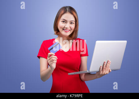 Shopping online. donna asiatica holding laptop e carta di credito pronti a pagare. Foto Stock