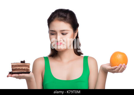 Dieta. dieta concetto. cibo sano. bella giovane donna asiatica scegliendo tra frutta e dolci Foto Stock