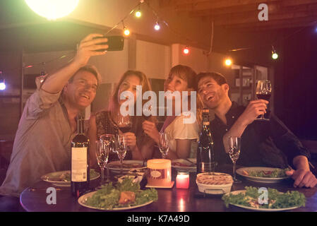 Amici in posa per il gruppo selfie a cena Foto Stock