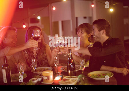 Le persone aventi la cena insieme all'aperto Foto Stock