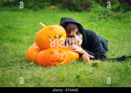 Bambino in costume spaventoso con la zucca Foto Stock