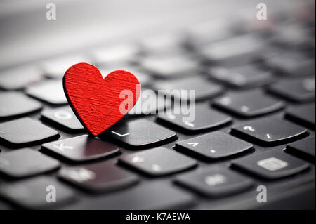 Piccolo cuore rosso sulla tastiera. internet dating concetto. Foto Stock