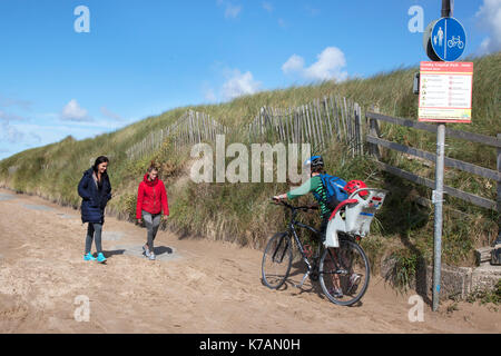 Crosby, Merseyside. Xv Sep, 2017. Regno Unito Meteo. Soleggiato ma breezy day presso la costa su Mariners modo. La lunga passeggiata da Crosby a Formby, è coperto con vento soffiato sabbia ostacolare gli amanti del jogging tenendo esercitare sulla spianata. Credito: MediaWorldImages/Alamy Live News Foto Stock