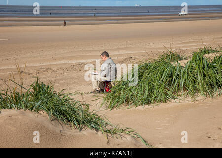 Crosby, Merseyside. Xv Sep, 2017. Regno Unito Meteo. Soleggiato ma breezy day presso la costa su Mariners modo. La lunga passeggiata da Crosby a Formby, è coperto con vento soffiato sabbia ostacolare gli amanti del jogging tenendo esercitare sulla spianata. Credito: MediaWorldImages/Alamy Live News Foto Stock