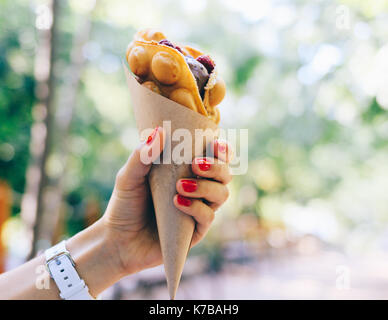 Close-up di fast food in una femmina di mano con red manicure Foto Stock