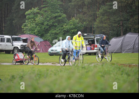 Famiglia Escursioni in bicicletta sotto la pioggia sulla vacanza in campeggio Foto Stock