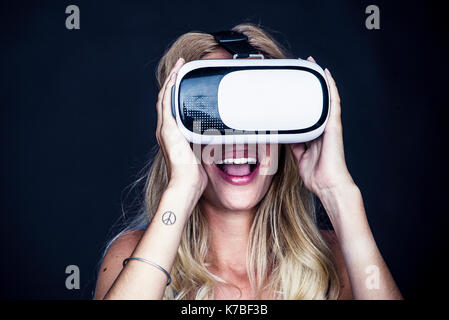 Giovane donna utilizzando la realtà virtuale simulator Foto Stock