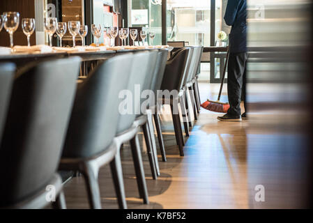 Persona spazzare il pavimento ristorante Foto Stock