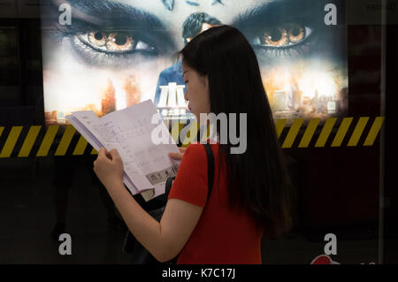 Giovane donna asiatica, cinese commuter in attesa per la metropolitana treno in arrivo nella stazione della metropolitana di Shanghai, Cina e Asia Foto Stock