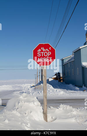 Ottagono stop rosso con in inuktitut (sillabiche), in inglese e in francese neve sul terreno Foto Stock