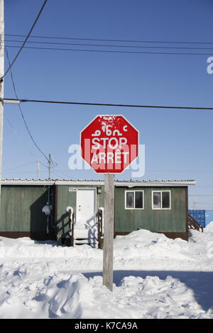 Ottagono stop rosso con in inuktitut (sillabiche), in inglese e in francese neve sul terreno Foto Stock