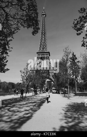 Una donna che si trova di fronte alla Torre Eiffel a Parigi, Francia. Foto Stock