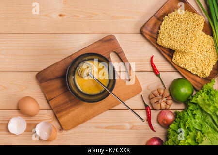 Pasta non cotta tagliatelle nel piatto su sfondo nero Foto stock - Alamy