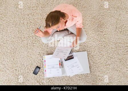 Angolo di alta vista della giovane donna facendo il calcolo a home Foto Stock