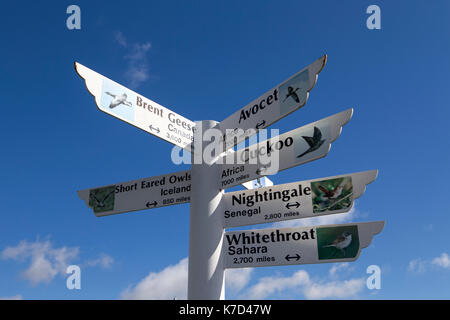 Segni che mostra la direzione e la distanza di migrazione di uccelli, presso l'Essex wildlife trust thurrock upcross natura parco vicino a Stanford-le-speranza, Essex. Foto Stock