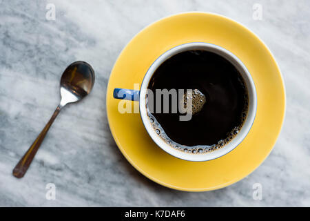 Vista aerea del nero caffè nella tazza e cucchiaio sul tavolo di marmo Foto Stock