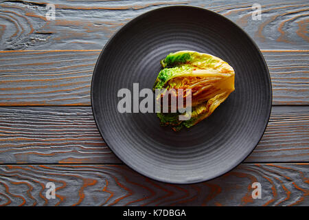 Indivia lattuga poco alla griglia con salsa vinaigrette sulla piastra nera Foto Stock