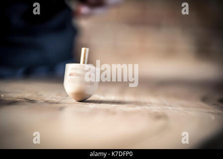 La filatura Dreidel sul tavolo Foto Stock