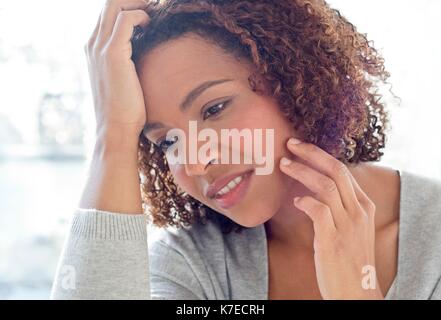 Ritratto di metà donna adulta di toccare la faccia. Foto Stock