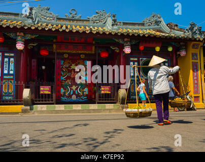 Hoian, vietnam, settembre 04 2017: unidentified Donna che cammina e appeso nella loro spalle il cibo, nei pressi del tempio di hoian in Vietnam Foto Stock