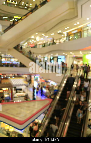 L'immagine verticale di offuscata shopping mall con così tante persone sulle scale mobili Foto Stock