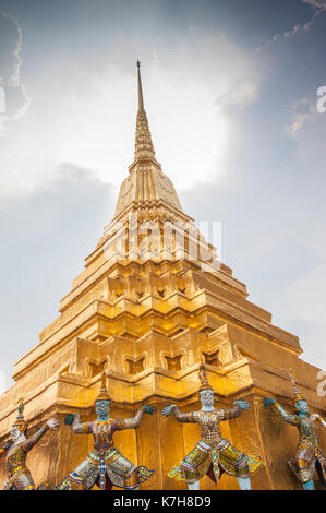 Bellissimo Chedi dorato ornato con mitici demoni guardiani intorno alla base. Wat Phra Kaew (Tempio del Buddha di Smeraldo), il Grande Palazzo, Thailandia Foto Stock