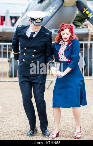 Coppia giovane dancing negli anni cinquanta a capi di abbigliamento. Donna in blu gonna e giacca, l uomo nella Royal Navy officer uniforme durante il saluto alla 40's popolare di fine settimana a Chatham Historic Dockyard. Foto Stock