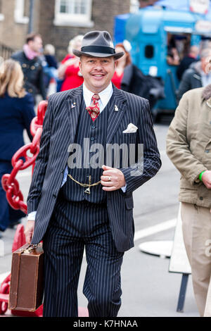 Inghilterra, Chatham Dockyard. Salutiamo annuale per gli anni quaranta evento. Uomo sorridente, reenactor vestito come tipico spiv bellica in tre pezzo tuta. Foto Stock