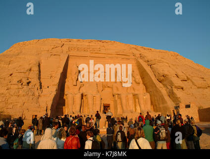 I turisti stranieri all'entrata dell'antico tempio di Abu Simbel e le quattro statue di Ramses II, Sito Patrimonio Mondiale dell'UNESCO, Egitto Foto Stock