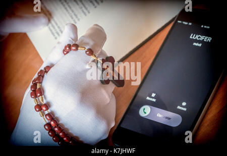 Lucifero chiamando una donna orante con un rosario Foto Stock