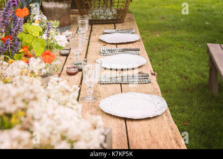 Tavolo in legno setup per party in giardino o la cena. Foto Stock