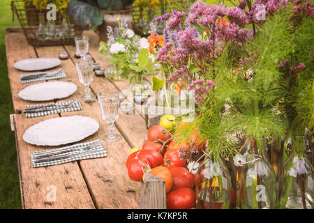 Tavolo in legno setup per party in giardino o la cena. Foto Stock