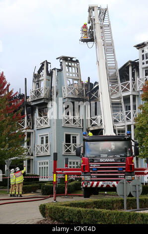 Vigili del fuoco rimangono presso la scena seguente un grande blaze in corrispondenza di un blocco di appartamenti in snodland, Kent. Foto Stock