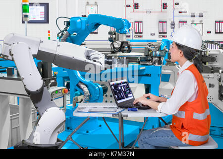 Donna di ingegneri software di sviluppo robotico automatizzato in linea di produzione, industria 4.0 concetto Foto Stock