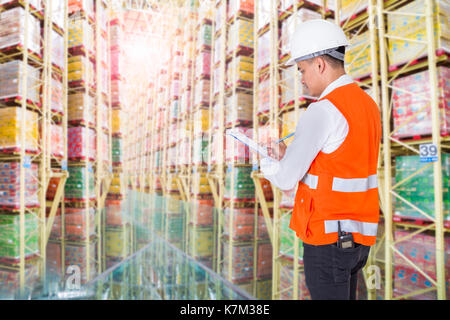 Giovane con appunti il controllo dei materiali di consumo a magazzino Foto Stock