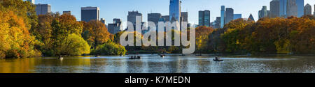 Il lago di Central Park in autunno con imbarcazioni a remi nel tardo pomeriggio. Manhattan, New York City Foto Stock