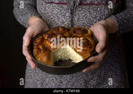 Donna detiene una piastra con torta nelle sue mani Foto Stock