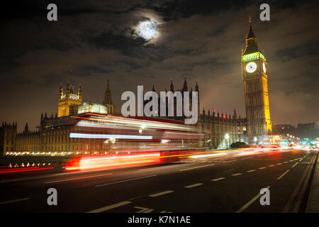 Palazzo di Westminster con il Big Ben di notte, rosso double-decker bus sul Westminster Bridge, motion blur, Londra, Inghilterra Foto Stock
