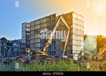 Sito in costruzione con demolito palazzo residenziale per essere demolita da due escavatori Foto Stock
