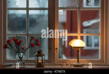 Vista da una finestra accogliente con lampada e fiori Foto Stock