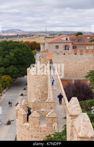 I turisti passeggiano lungo la parte superiore delle mura medievali della città di Avila, Spagna Foto Stock